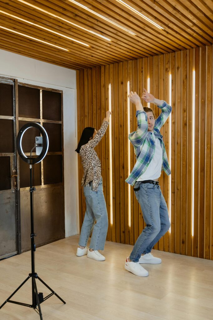 Energetic couple dances in modern living room, creating content for social media.